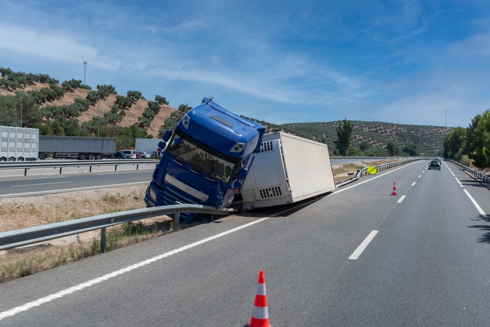 Truck with an accident refrigerated semi-trailer, overturned by the exit of the highway in the median of the highway