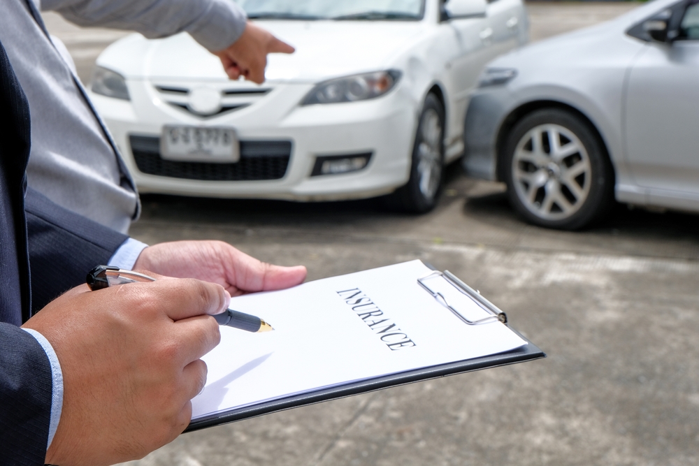 Loss Adjuster Insurance Agent Inspecting Damaged Car